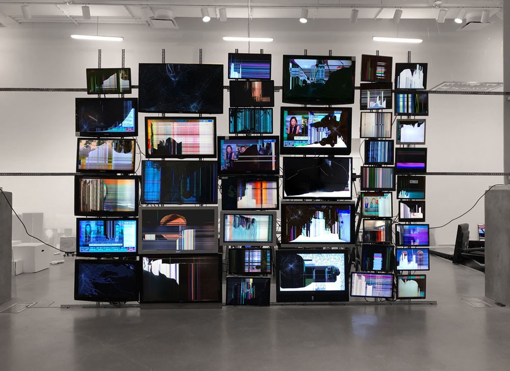 Installation of the artist Penelope Umbrico Accumulation of Broken Screens forming a new giant screen